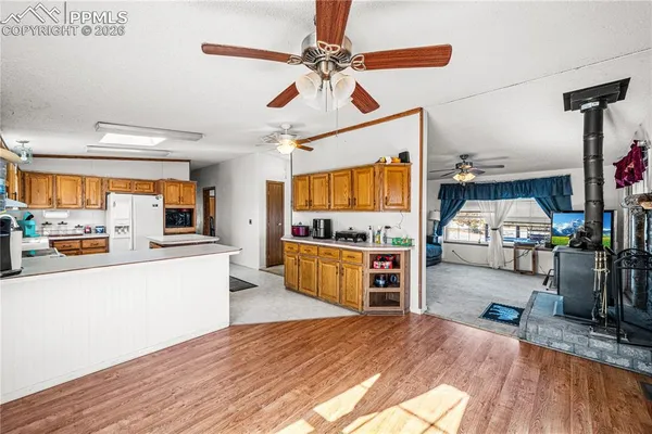 a kitchen with stainless steel appliances wooden floor and a refrigerator