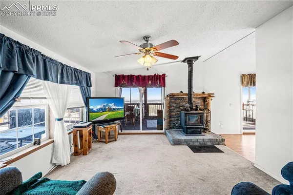a living room with furniture a flat screen tv and kitchen view