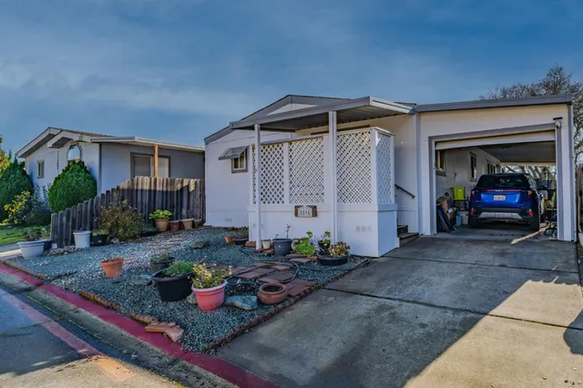 a front view of a house with entryway and potted plants