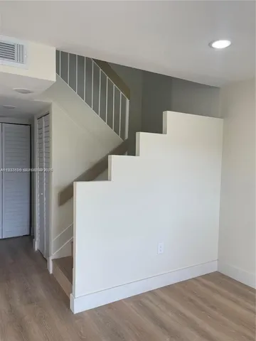 a view of hallway with stairs and wooden floor