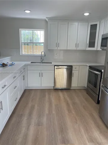 a kitchen with granite countertop a stove sink and cabinets