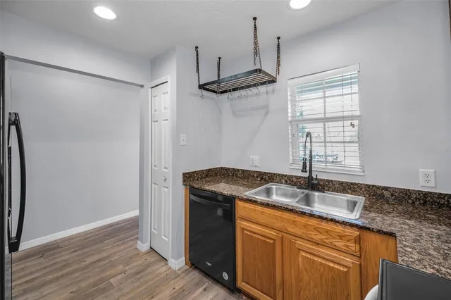 a kitchen with stainless steel appliances granite countertop a sink and a refrigerator