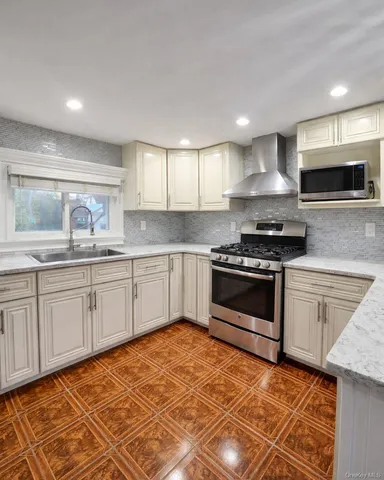 a kitchen with granite countertop a stove a sink and a microwave