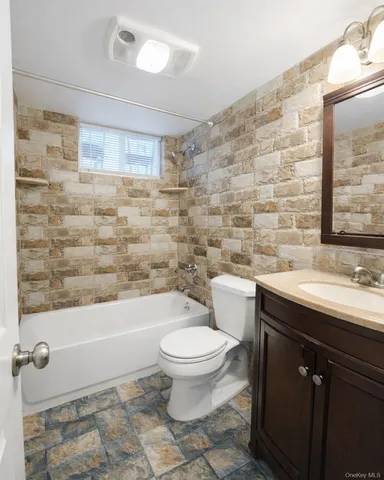 a bathroom with a granite countertop toilet a sink and mirror