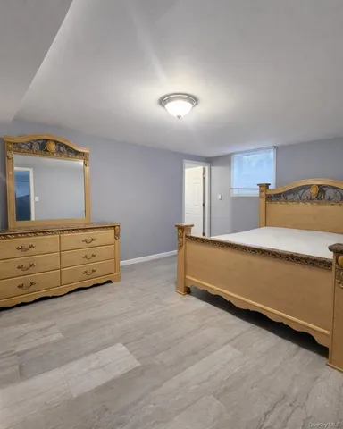 a spacious bedroom with a bed and a dresser