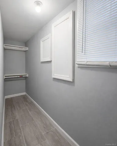 a view of a small space with wooden floor and a window