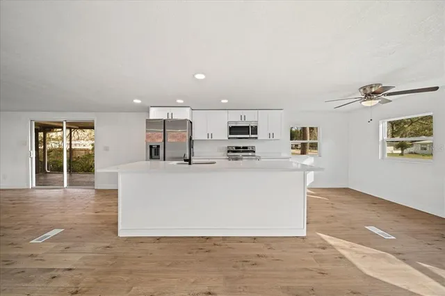 a kitchen with stainless steel appliances a sink stove and cabinets