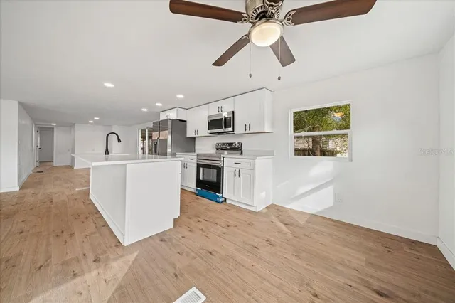 a kitchen with stainless steel appliances a stove sink and cabinets