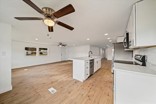 a kitchen with kitchen island a sink appliances and cabinets