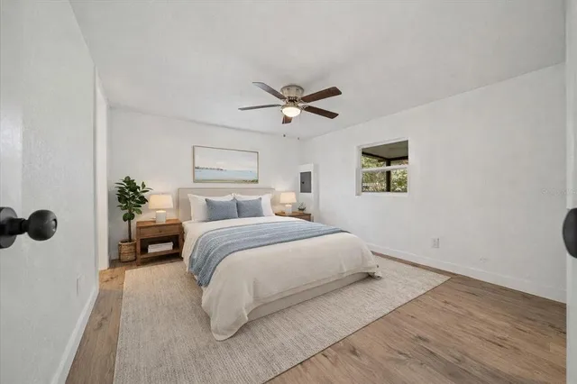 a view of a livingroom with a ceiling fan & windows