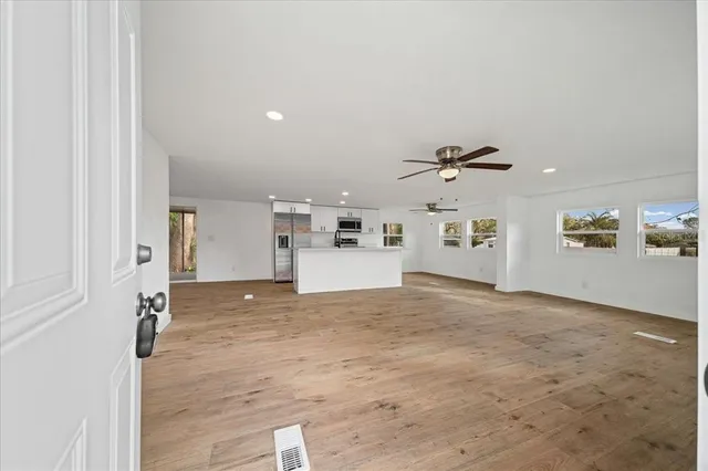 a view of empty room with wooden floor and window