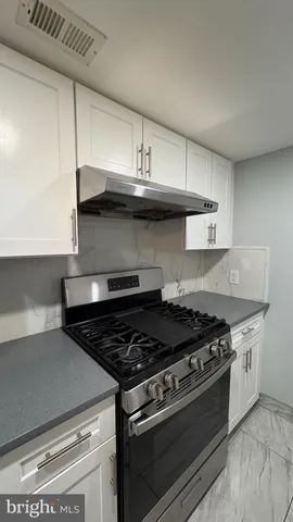 a stove top oven sitting inside of a kitchen