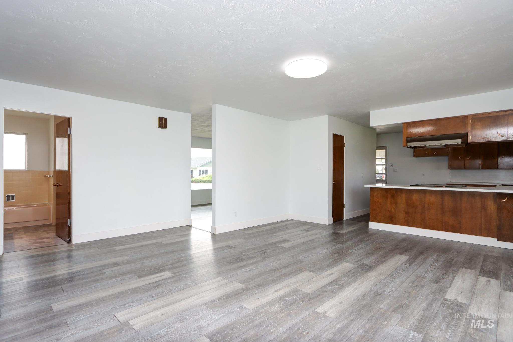 801 Thompson Avenue Nyssa, OR 97913 - Photo 8 of 46 Open concept living space featuring wood-finish flooring, white walls, and a contemporary ceiling light fixture