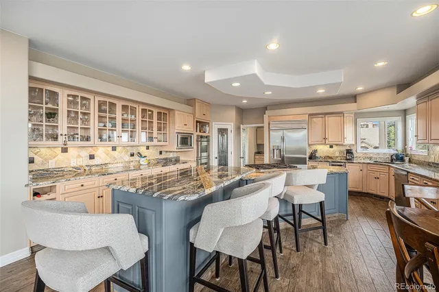 a room with kitchen island furniture a large window and a sink