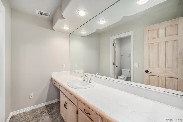 a bathroom with a granite countertop sink toilet and shower
