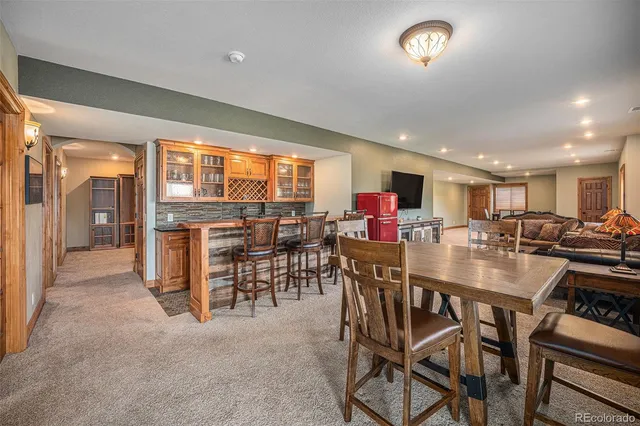 a living room with stainless steel appliances granite countertop furniture a couch and a window