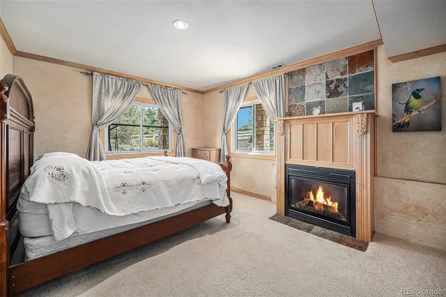 a view of a white house with a yard and lawn chairs under an umbrella