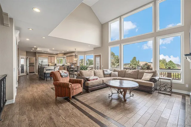 a living room with furniture a fireplace a flat screen tv and a large window