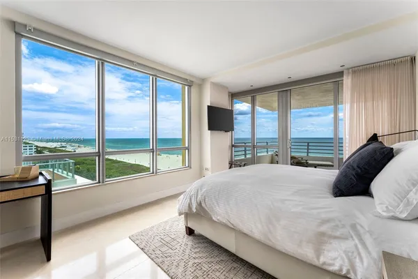 a large bed sitting in a bedroom next to a window