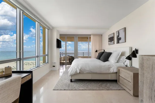 a spacious bedroom with a bed and glass door