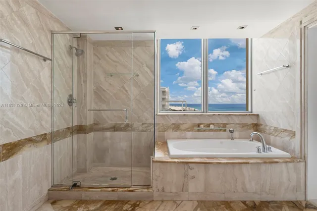 a en suite bathroom with a granite countertop tub sink a mirror and shower