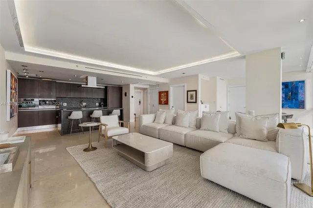 a living room with furniture and a view of kitchen
