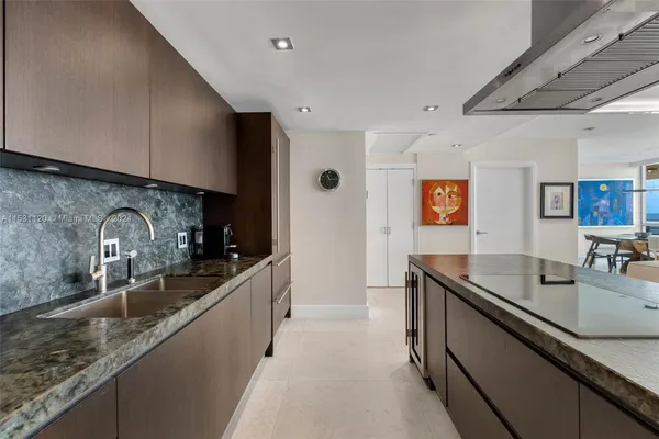 a kitchen with granite countertop stainless steel appliances a sink a counter top space and cabinets