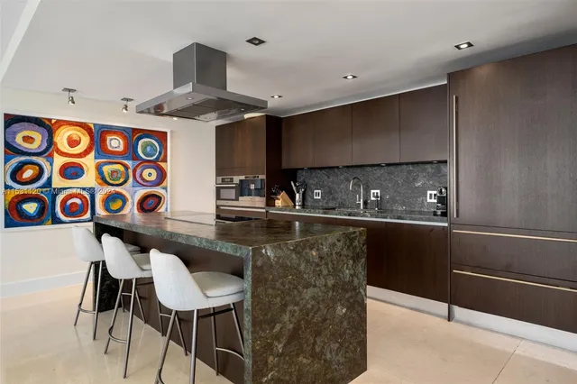 a kitchen with stainless steel appliances granite countertop a sink and a refrigerator
