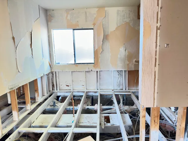 an empty room with sliding glass door and chandelier fan