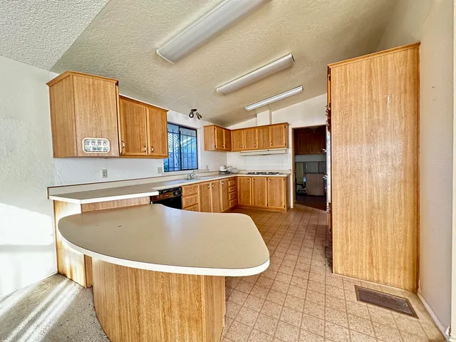 a kitchen with stainless steel appliances granite countertop a sink and a refrigerator