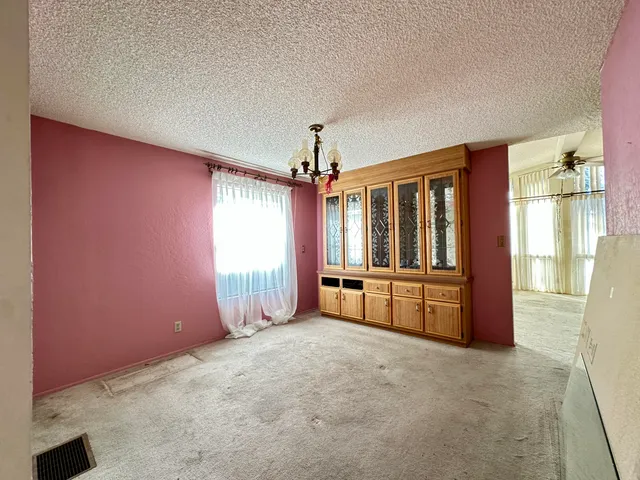 an empty room with windows and ceiling fan