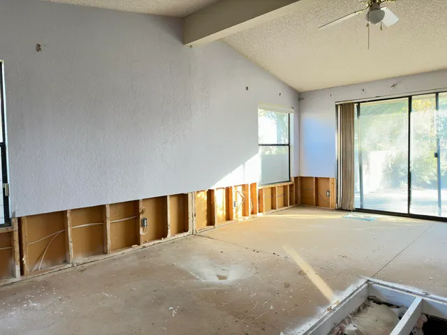 a room with lots of white furniture and a window