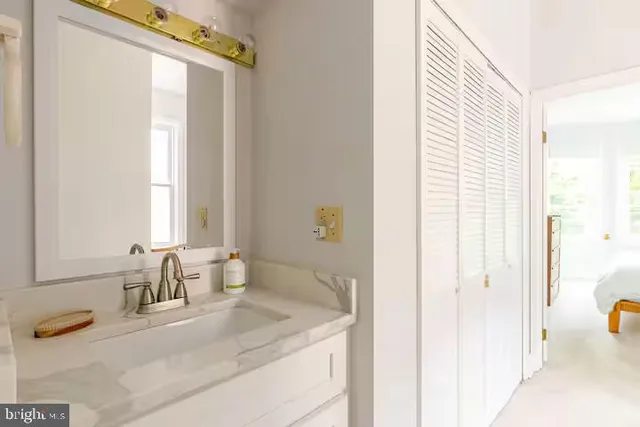 a bathroom with a granite countertop sink and a mirror