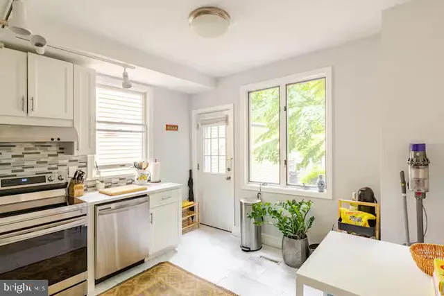 a kitchen that has a sink and chairs