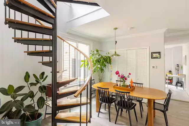 a view of a dining room with furniture and a potted plant