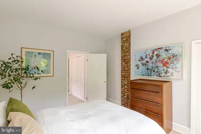 a bedroom with a bed and a painting on the wall