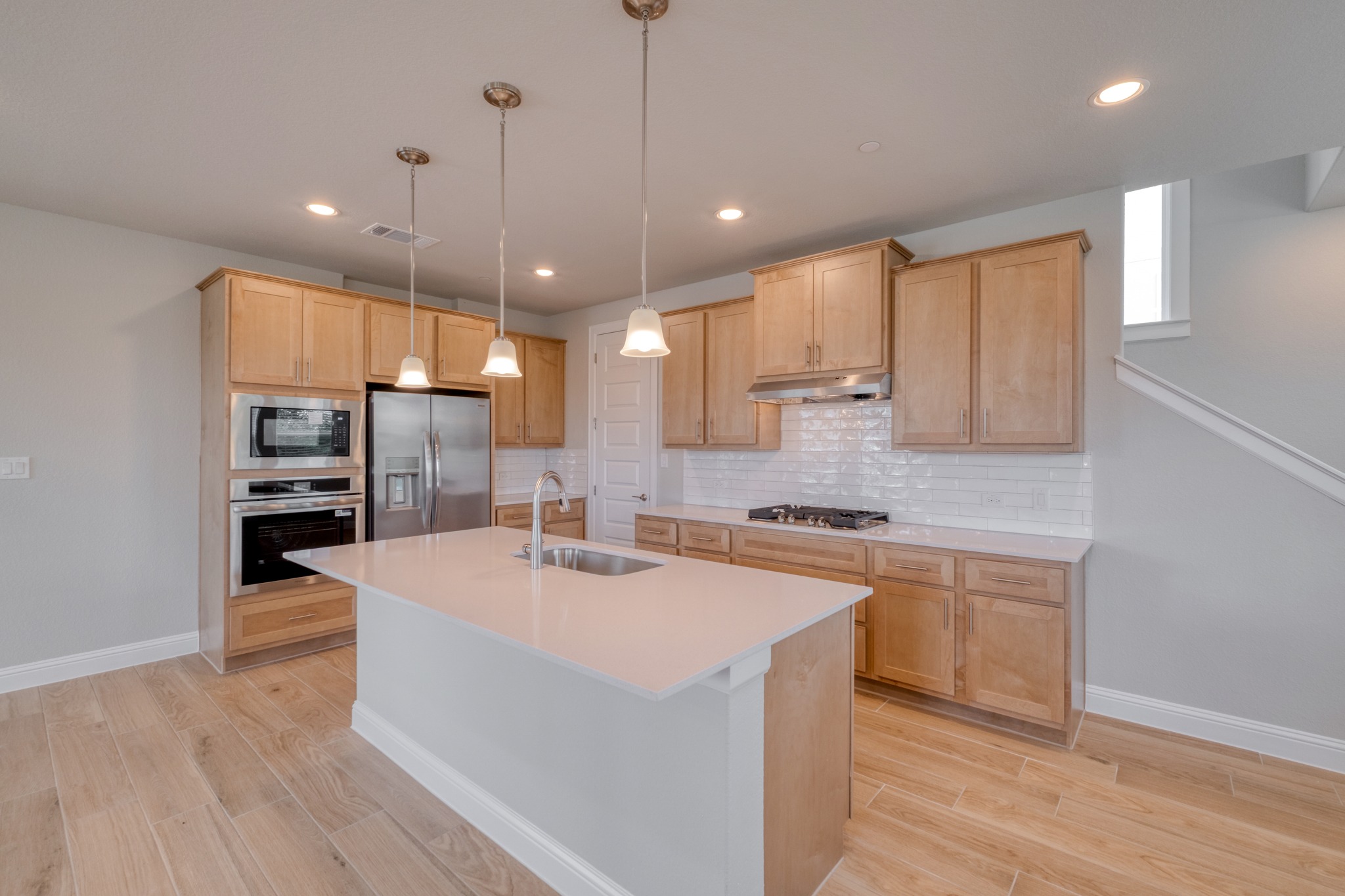 2605 Sam Bass Road, Unit 44 Round Rock, TX 78681 - Photo 10 of 26 Bright, open-concept kitchen with sleek white countertops and warm wood cabinetry, ideal for entertaining.