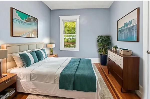 a bedroom with a bed and a potted plant