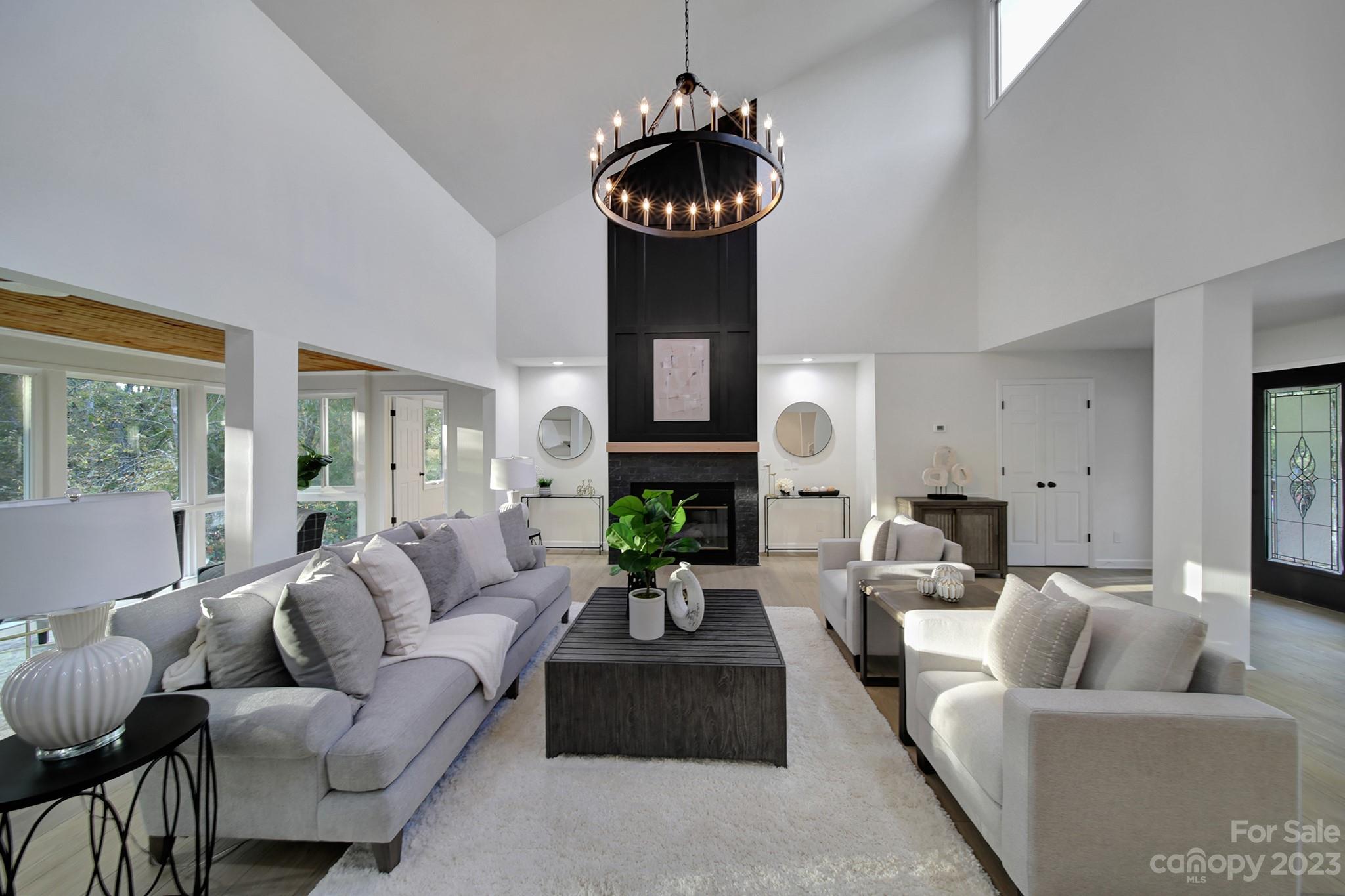 25068 Timberlake Drive Tega Cay, SC 29708 - Photo 6 of 48 a living room with furniture a fireplace and a chandelier