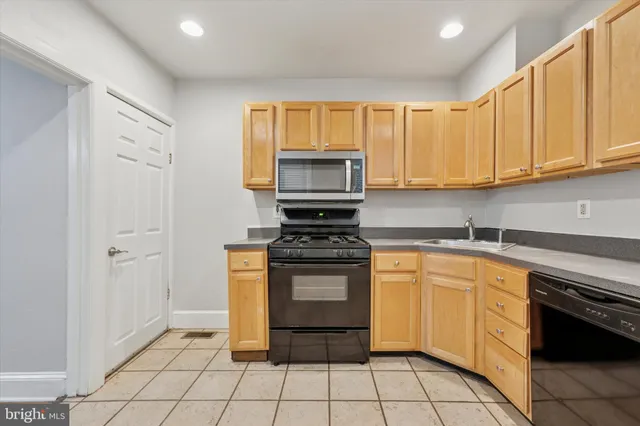 a kitchen with a stove top oven cabinets and a window