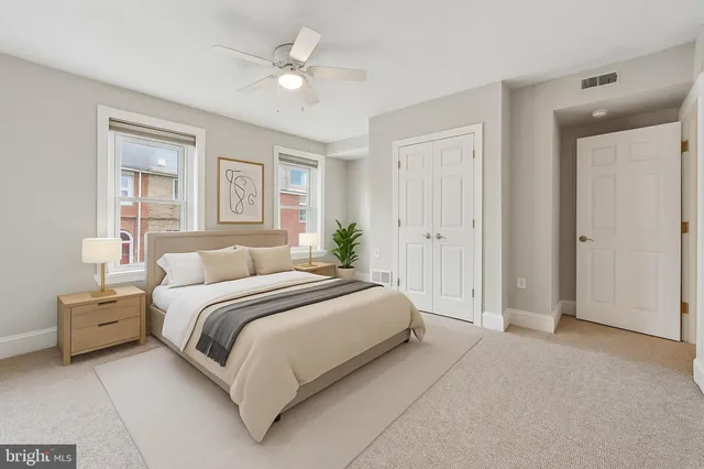 a spacious bedroom with a bed and a chandelier