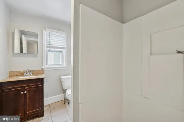 a bathroom with a toilet a sink a vanity and mirror