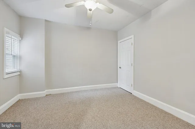 an empty room with a chandelier fan