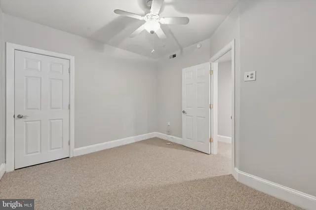 an empty room with chandelier fan