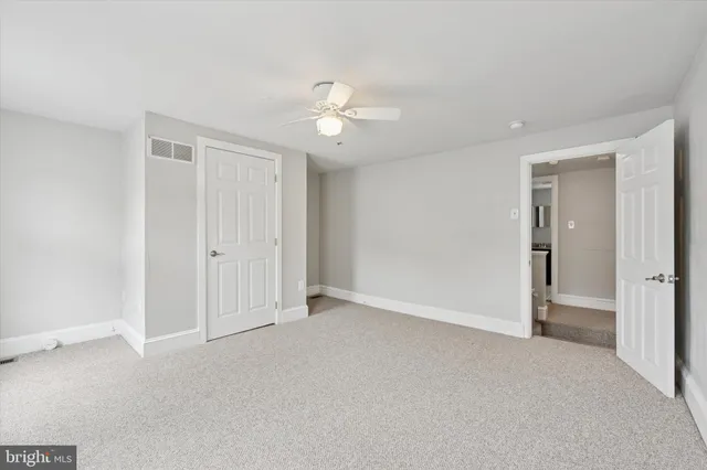 an empty room with a ceiling fan and a window