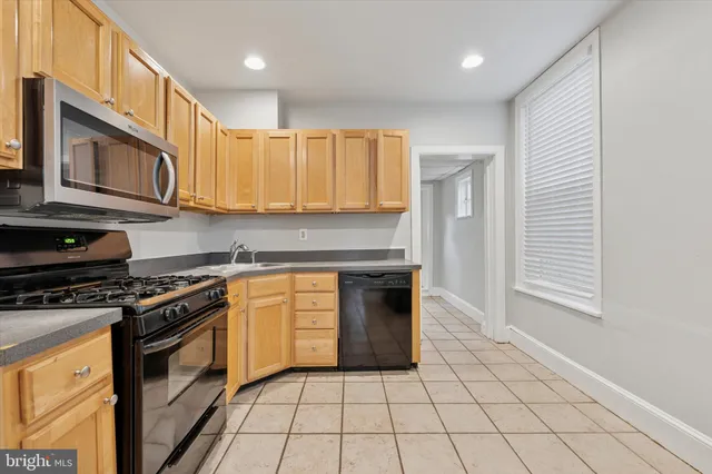 a kitchen with granite countertop a stove top oven microwave and cabinets