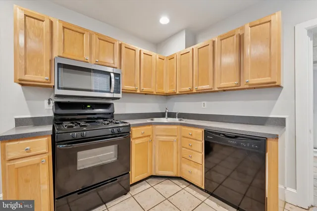 a kitchen with granite countertop cabinets stainless steel appliances and a sink