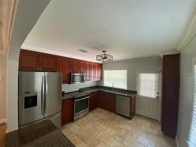 a kitchen with stainless steel appliances granite countertop a refrigerator and a sink