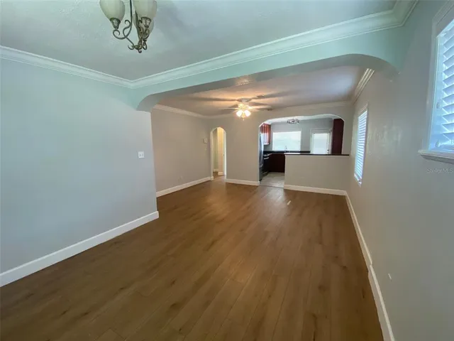 a view of a hallway with wooden floor and a chandelier