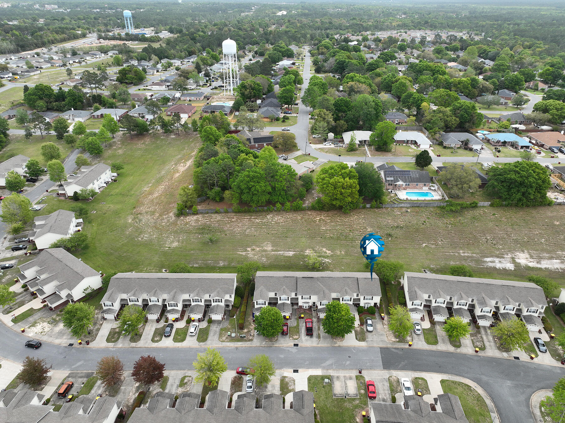 an aerial view of ocean and residential houses with outdoor space